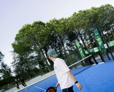Mavi padel kortunda raketiyle oyuna hazırlanan sporcu.