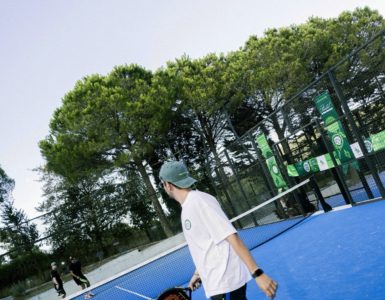 Mavi padel kortunda raketiyle oyuna hazırlanan sporcu.
