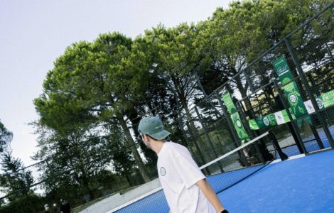 Mavi padel kortunda raketiyle oyuna hazırlanan sporcu.