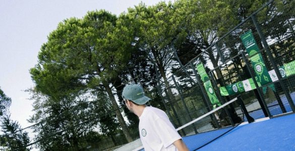 Mavi padel kortunda raketiyle oyuna hazırlanan sporcu.