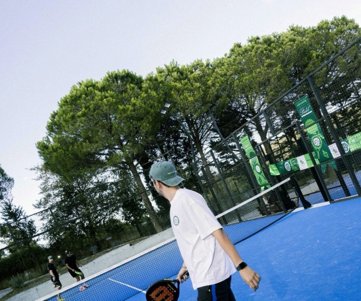 Mavi padel kortunda raketiyle oyuna hazırlanan sporcu.