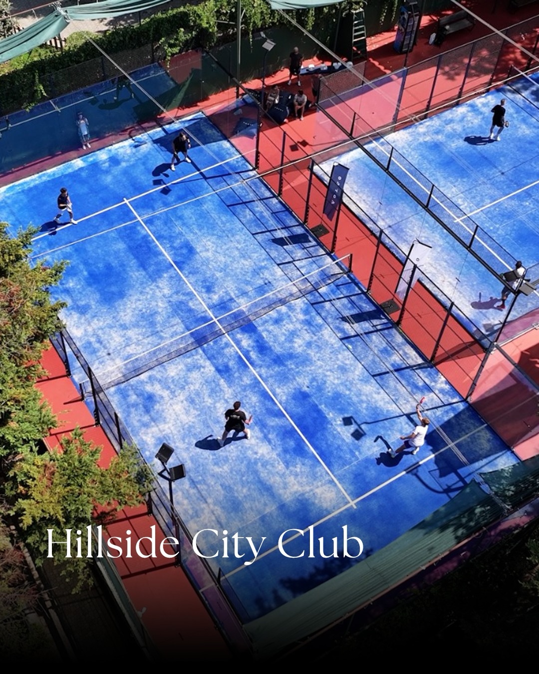 Hillside City Club’ın yukarıdan görünen mavi padel kortlarında oynayan takımlar.